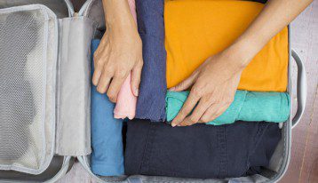 person packing a suitcase