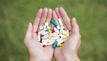 hands holding variety of pills