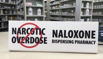 naloxone dispensing pharmacy sign sitting on pharmacy counter