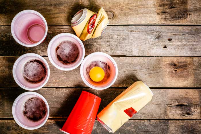 solo cups with alcohol and beer cans on wood table