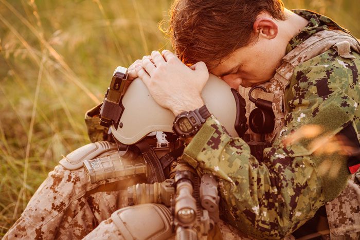 What Can Be Done to Help Veterans with Addiction, US soldier depressed sitting in field