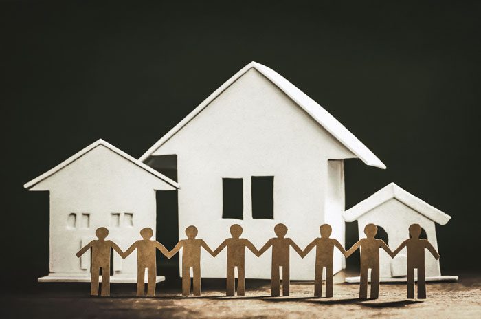 Benefits of Transitional Living After Addiction Treatment, cut outs holding hands, houses