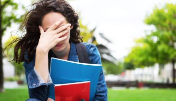 distressed female college student - hand over face