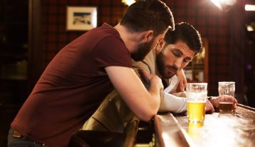 Alcohol and heroin impact the central nervous system, man worried about friend at bar