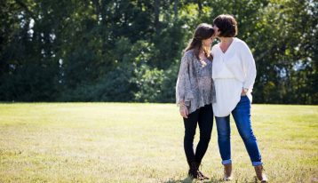 mom and young adult daughter being affectionate