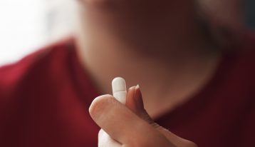 closeup of teen holding pill