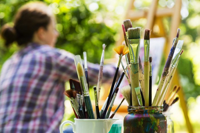 woman painting outdoors - art therapy - holistic rehab