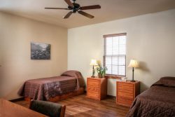 bedroom with desk, ceiling fan, and two single beds