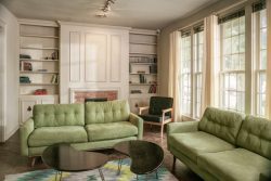 den or home library with built in white bookcase and light green sofas