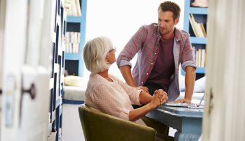 adult son talking to senior mother - enabling