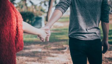 couple holding hands - pulling away from each other - spouse