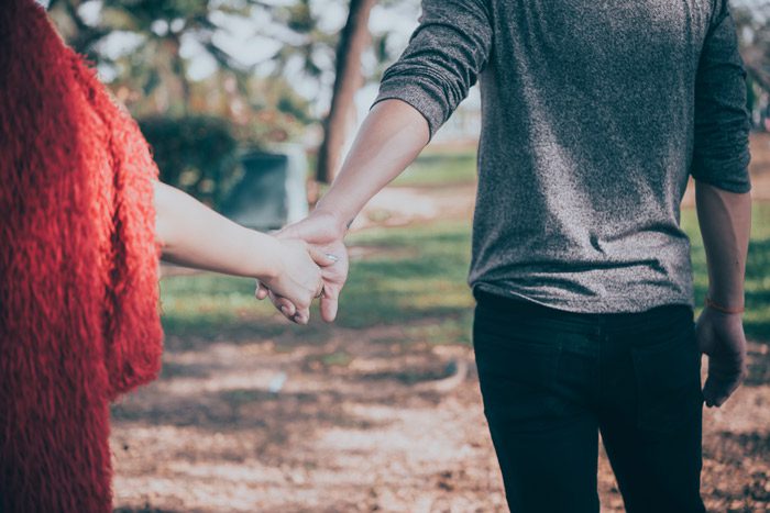 couple holding hands - pulling away from each other - spouse