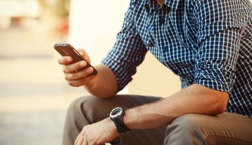 man sitting outside making a call on his cell phone - treatment