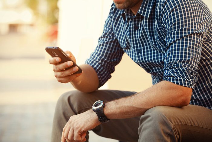 man sitting outside making a call on his cell phone - treatment