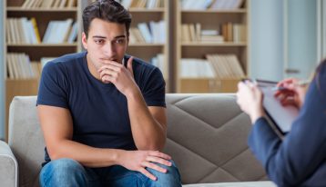 What Is Cognitive Behavioral Therapy?, young man in therapy session with counselor - CBT