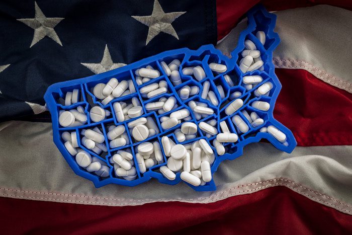 pills in shape of the United States on US flag - epidemic