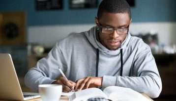 young handsome African American man doing college homework - high stress