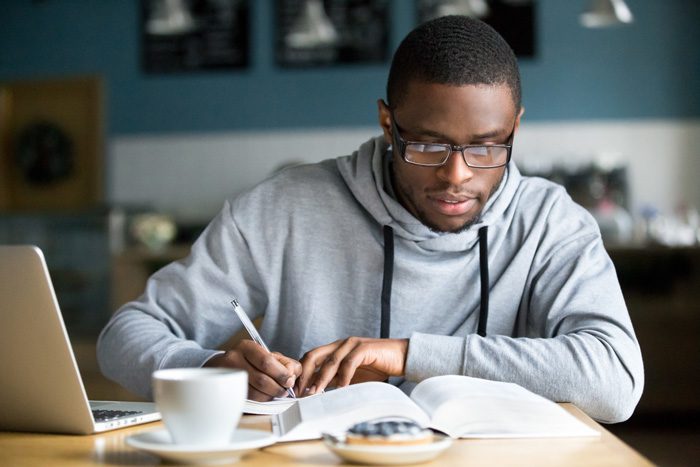 young handsome African American man doing college homework - high stress