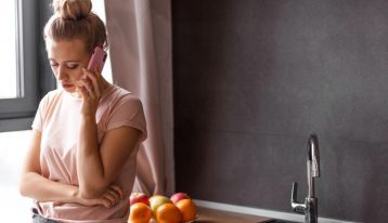 young woman on cell phone at home - pandemic