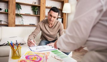 man doing art therapy in therapist's office - residential addiction treatment