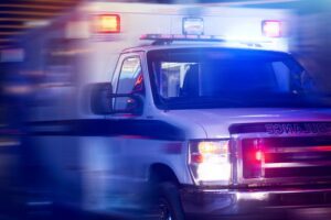 close up action shot of ambulance with lights on - harm reduction