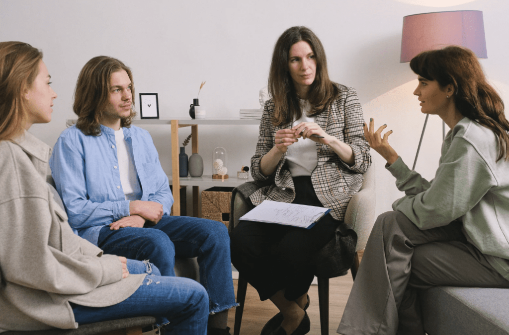 A group of people talking to a therapist.
