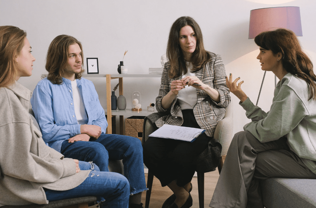 A group of people talking to a therapist.